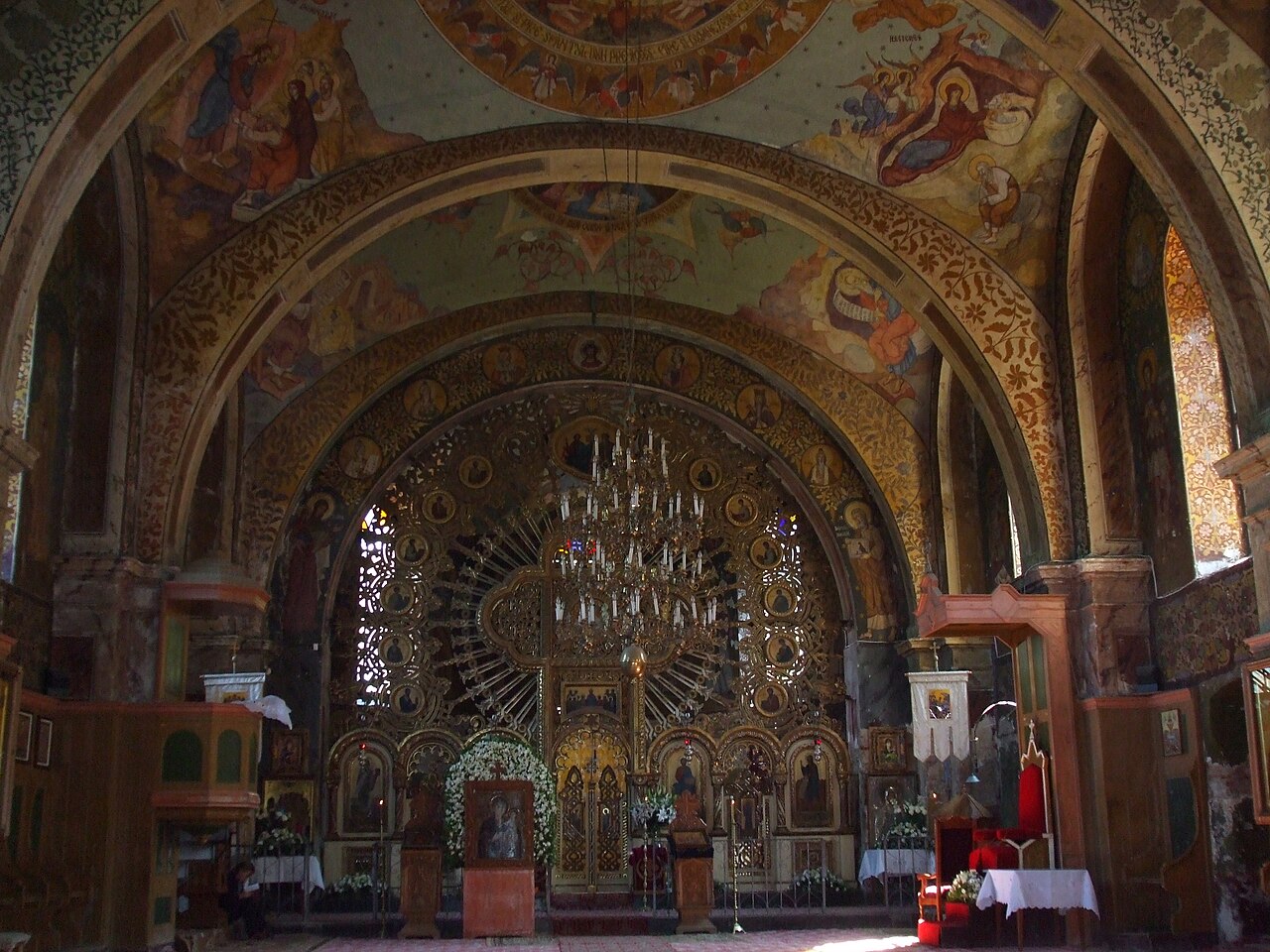 Interiorul bisericii vechi de zid: iconostasul solar, bolta pictată și naosul.