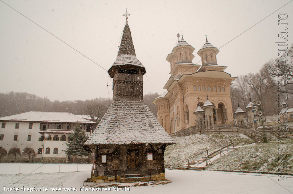 Biserica de lemn strămutată și biserica nouă de zid în aceeași vedere.