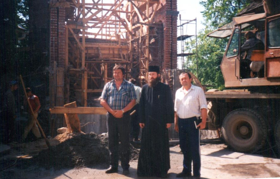 Structura și schelele bisericii noi în construcție; persoanele ascund partea de jos.