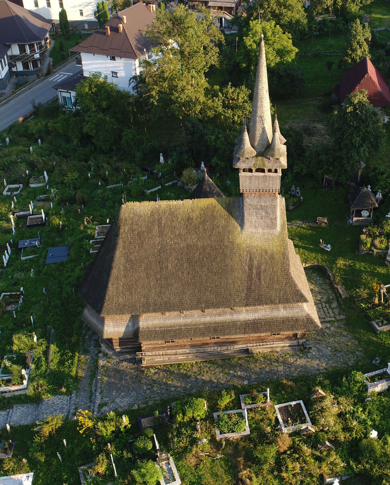 Vedere aeriană apropiată a șindrilei, turnului cu patru turnulețe și absidei.