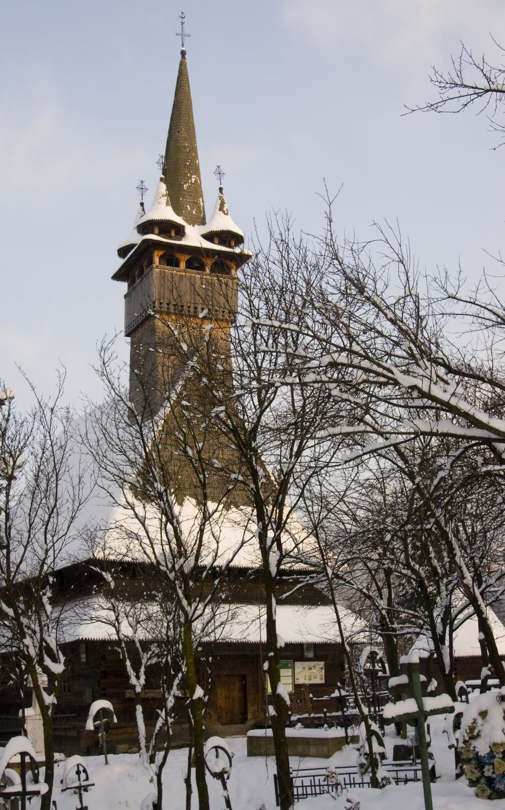 Biserica Josani în perioada de iarnă, fără frunziș în fața turnului.