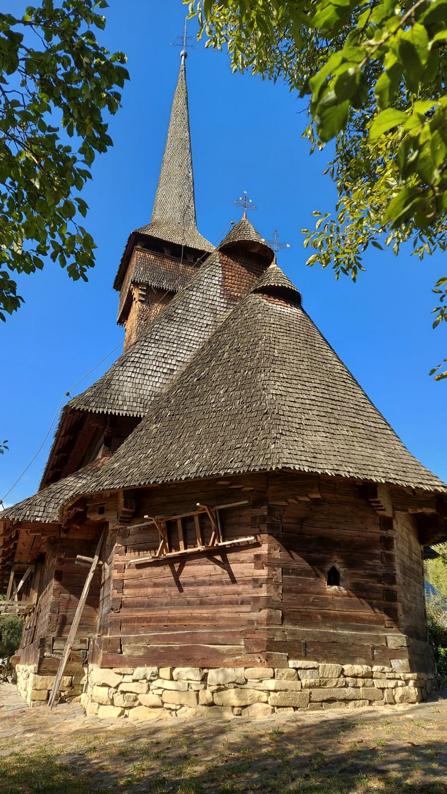 Absida de bârne și pantele acoperișului, vedere de la sol.