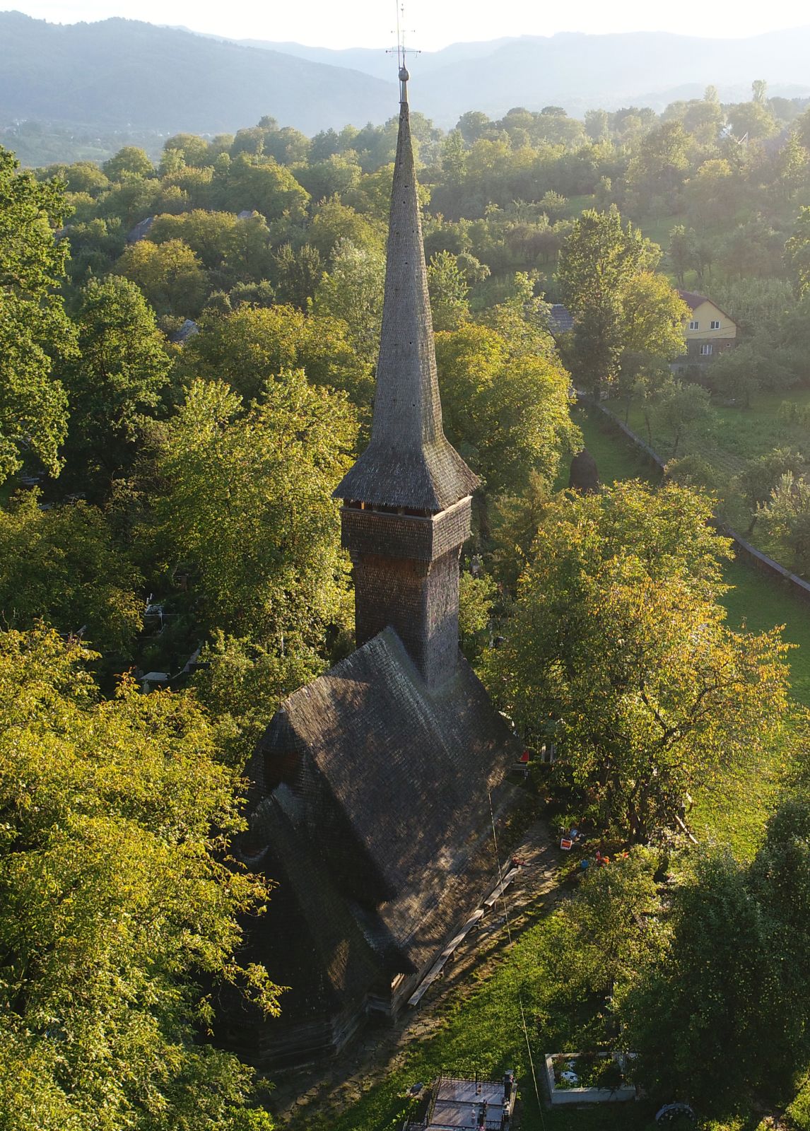 Vedere aeriană cu biserica și relieful satului în fundal.