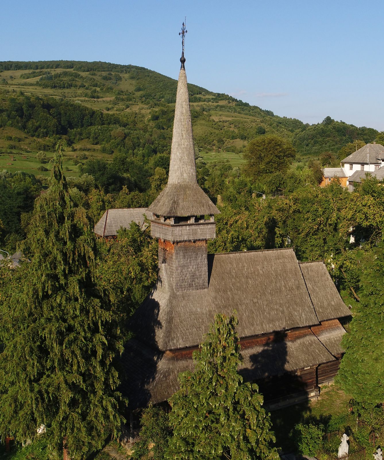 Vedere aeriană oblică a bisericii istorice și versantului.
