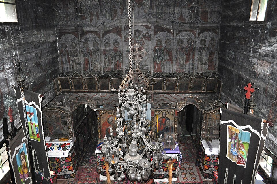 Iconostasul, partea superioară pictată și mobilierul naosului.