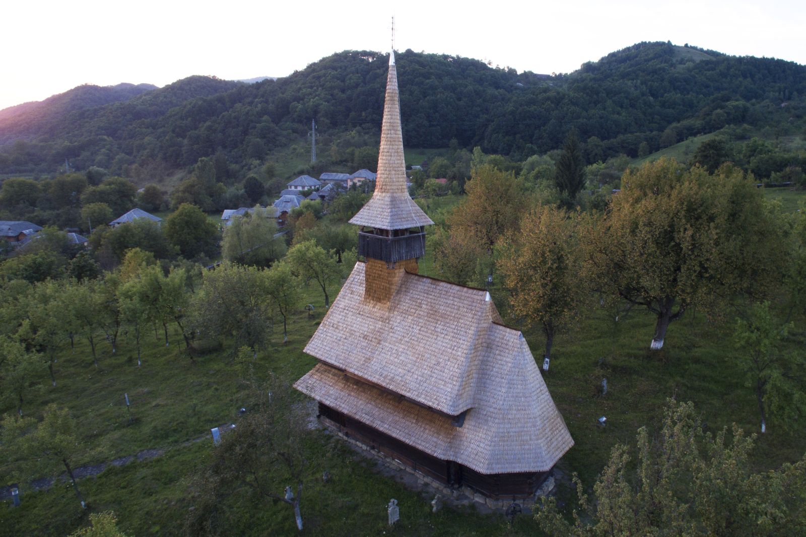 Vedere aeriană apropiată a absidei, acoperișului și turnului bisericii istorice.