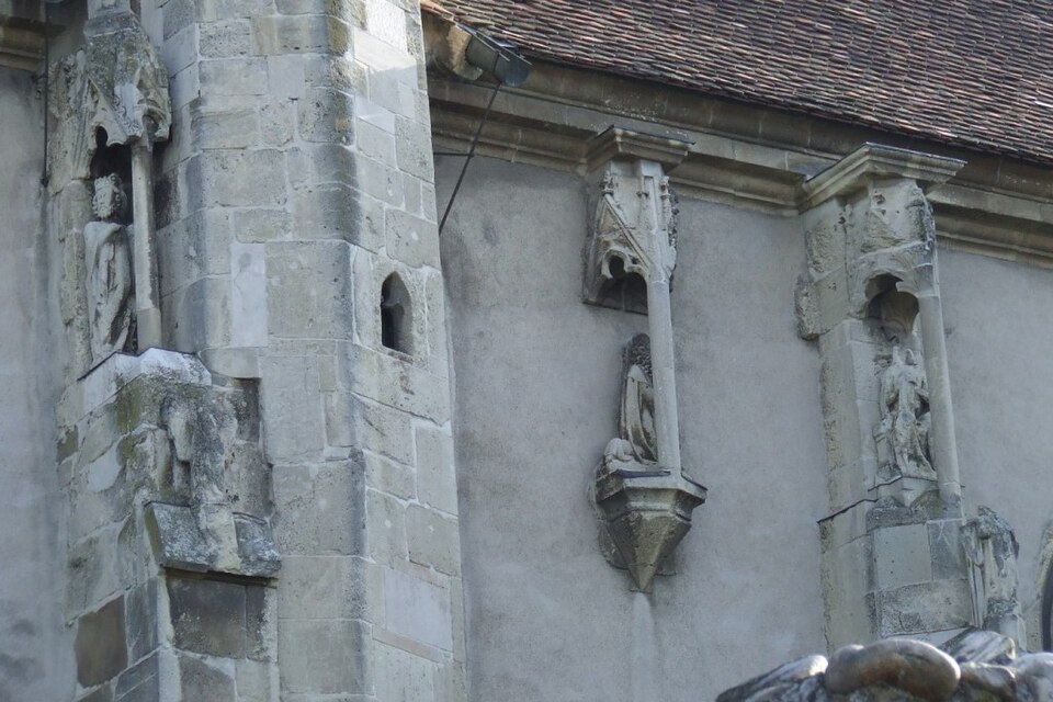 Zidul corului, contraforturi și sculptură exterioară.